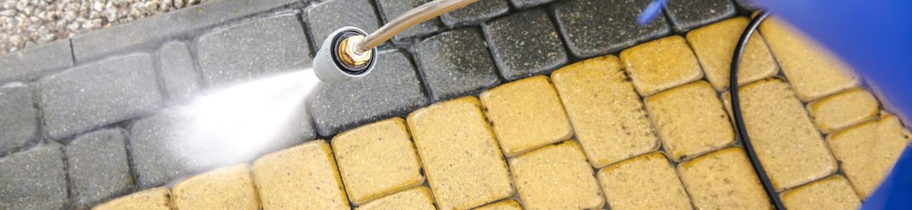 Driveway Bricks Pavement Washing Using Pressure Washer. Closeup Photo.